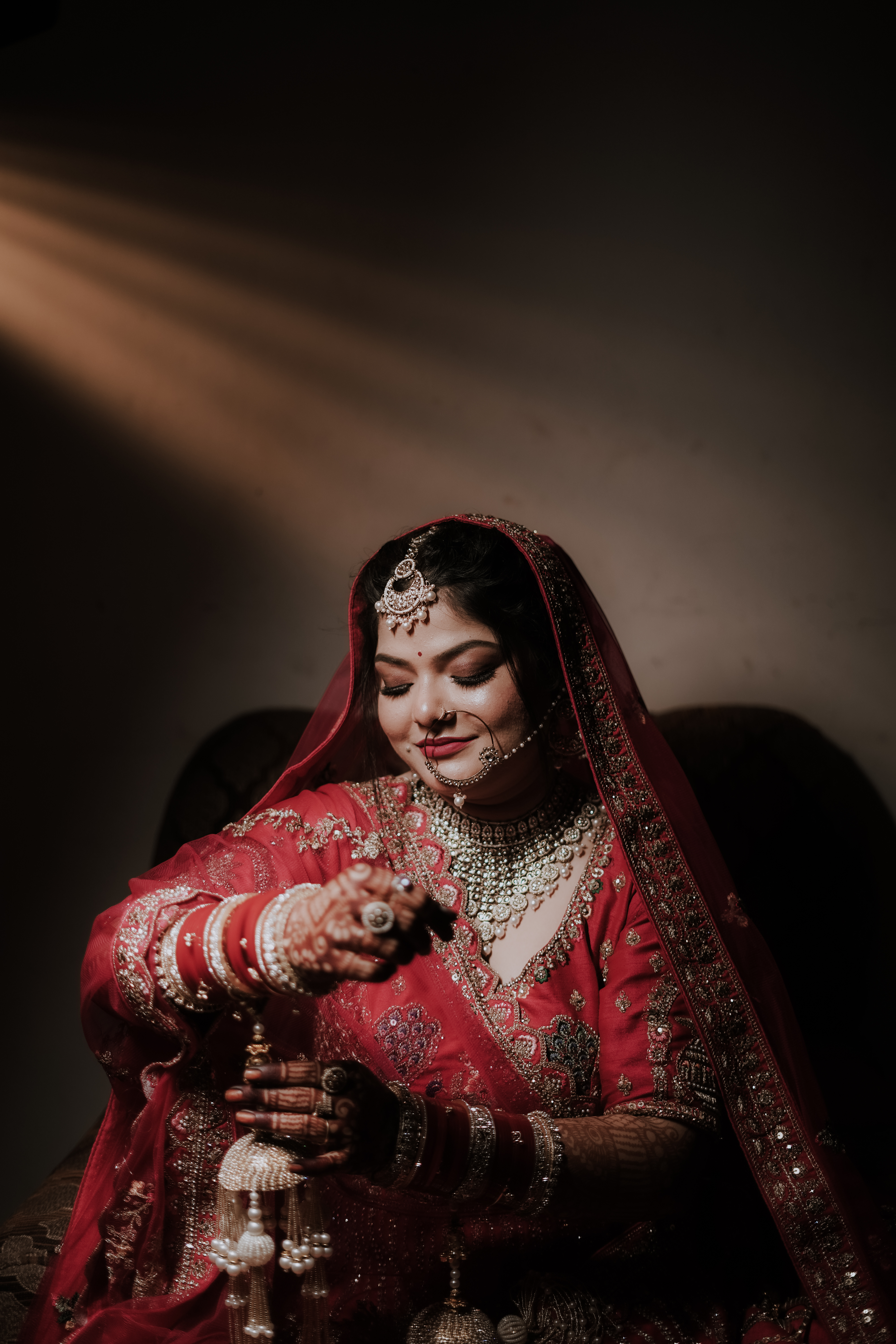 Royal Indian bride in crimson lehenga with golden sunbeam and traditional kalire